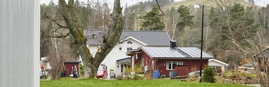 Trädäck utanför grått trähus.