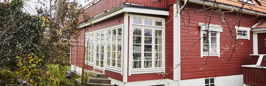 Ett rött trähus med en attefallstillbyggnad.