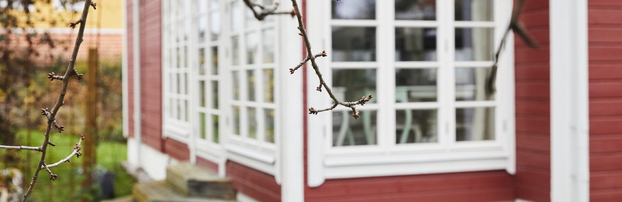 Ett rött trähus med en attefallstillbyggnad.