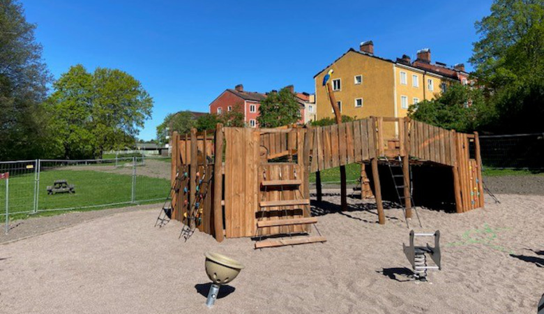 En lekplats med en träkonstruktion och en rutschkana.