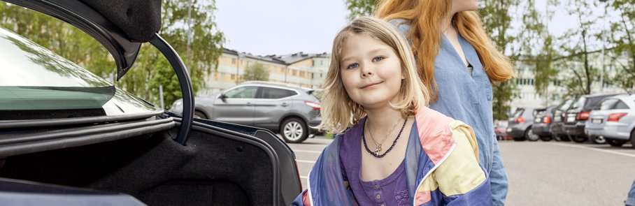 Flicka packar in väskor i bil