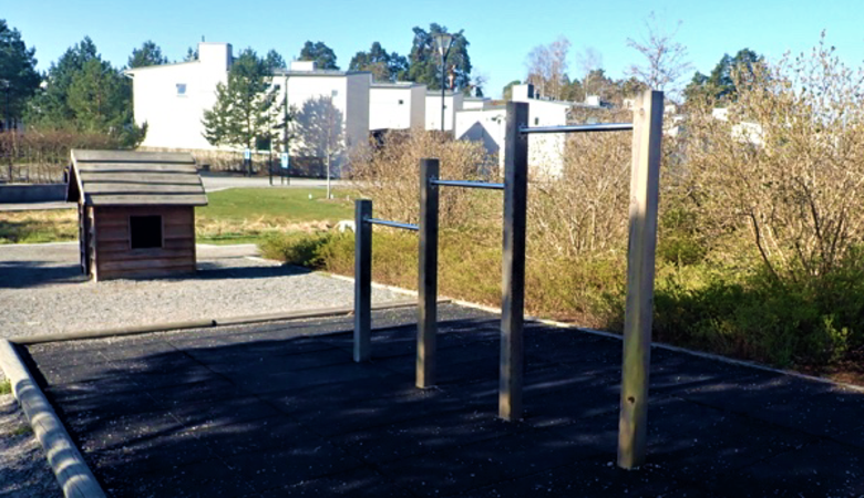 En park med en lekstuga med klätterställning.