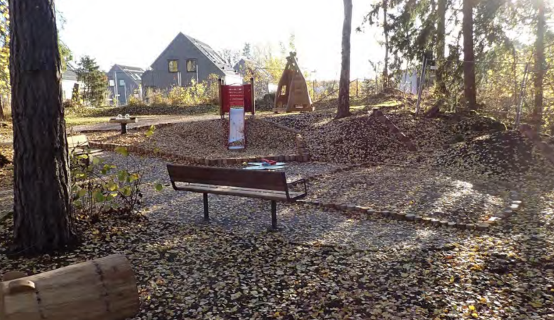 En parkbänk som sitter mitt i en skog.