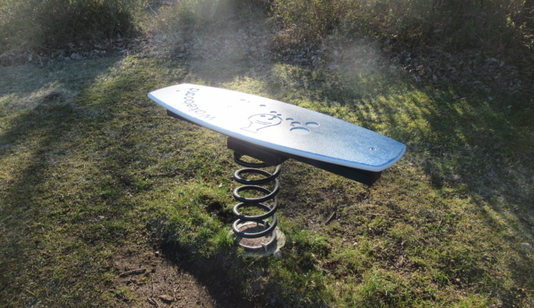 En surfbräda som sitter på toppen av en metallfjäder.
