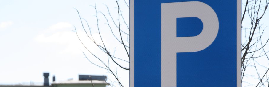 En blå parkeringsskylt som sitter vid sidan av en väg.