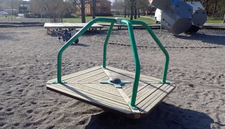 En vippgunga i sanden i en park.