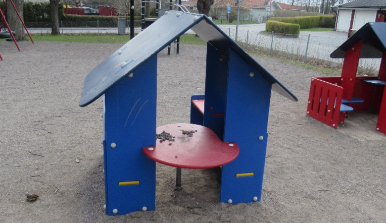 En lekplats med ett rött bord och en blå struktur.