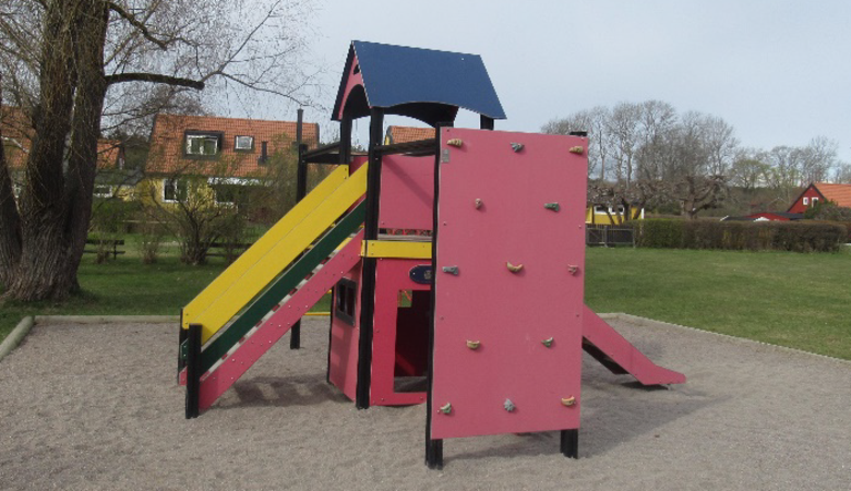 En lekplats med en rosa rutschkana och ett blått tak.